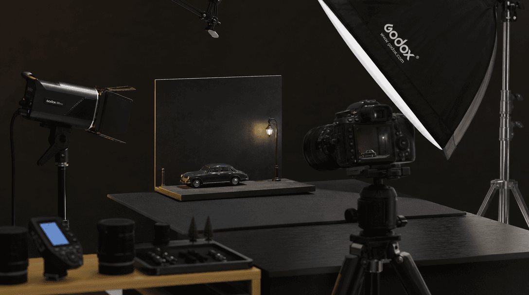 Professional product photography setup with miniaturized objects and studio lighting equipment, dark editorial style com