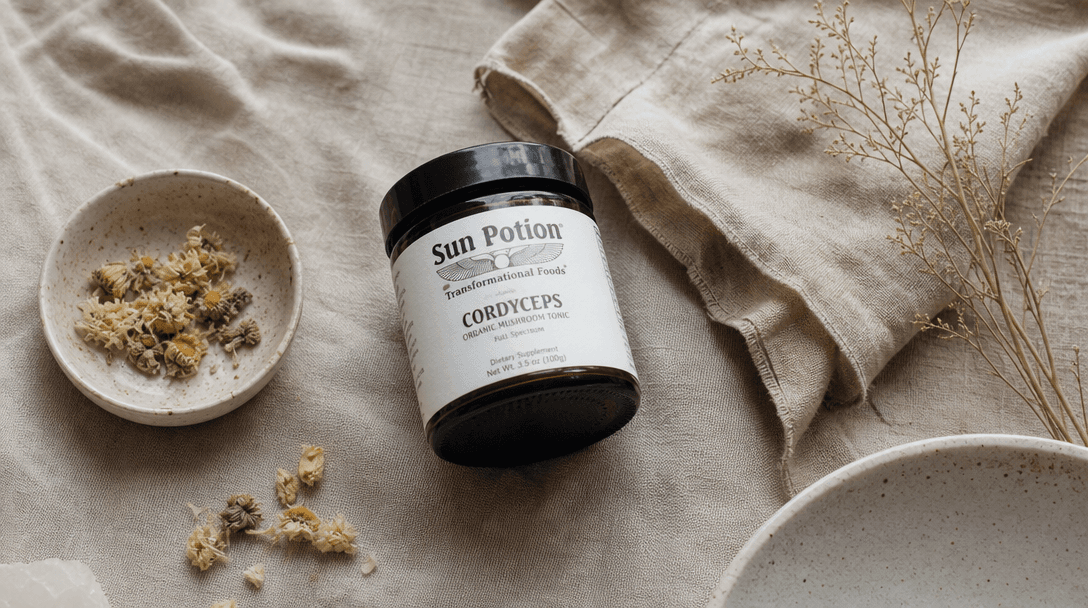 Casual flat-lay of lifestyle objects — a supplement jar, dried botanicals, a linen cloth, a small ceramic dish — arrange