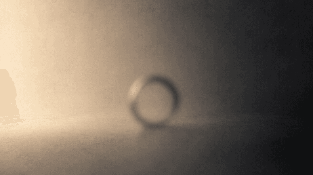 Abstract gradient study of a studio background: a smooth transition from warm ivory cream at left to deep charcoal at ri