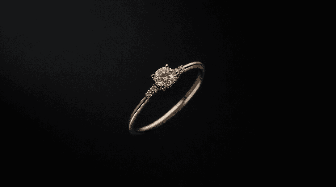 A delicate ring floating in near-void darkness, set against a controlled background gradient transitioning from deep cha
