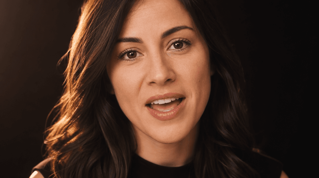 Close-up of a person speaking with natural lip movement and genuine expression. Soft warm key light from the left, profe