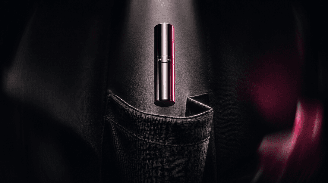 An abstract still life expressing portability: a small polished cosmetic cylinder suspended above folded black fabric sh