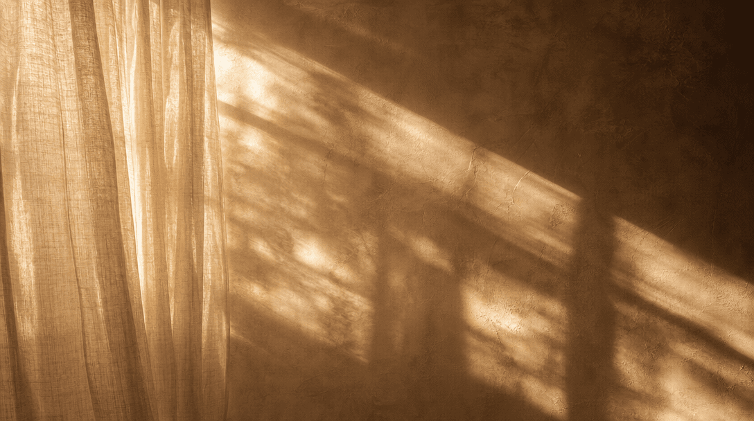 Abstract cinematic frame: sunlight streaming through sheer natural linen curtains in a bare room, casting soft diffused 