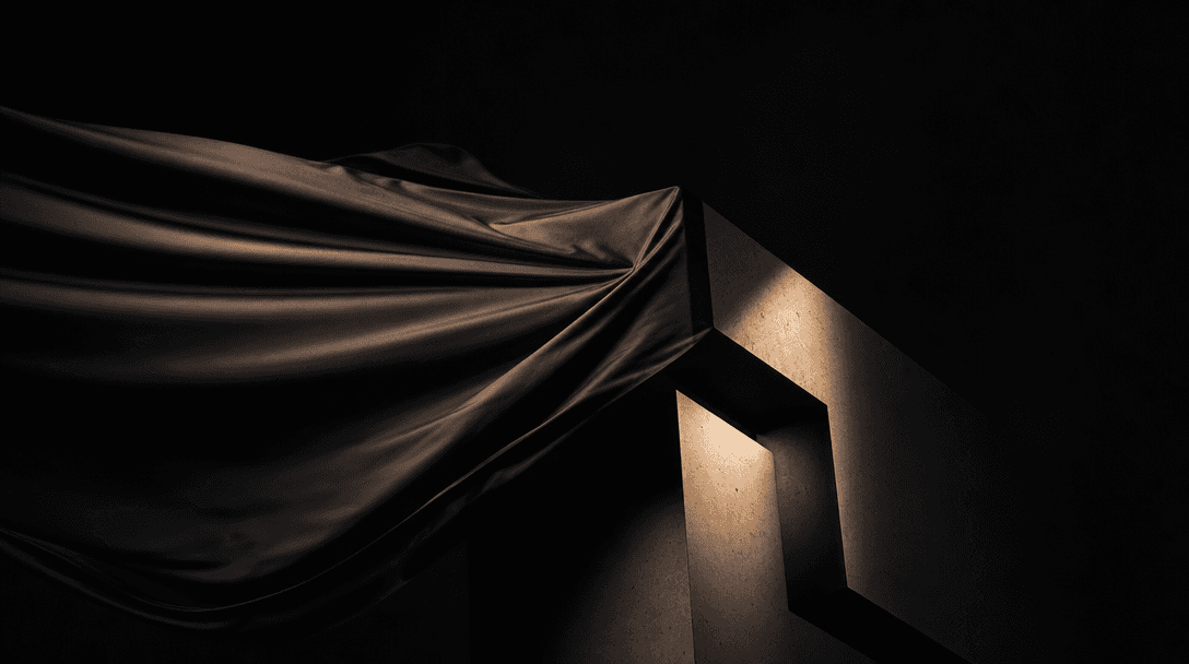 Abstract motion study — dark silk fabric unfurling in slow motion against a near-black background, gradually revealing a