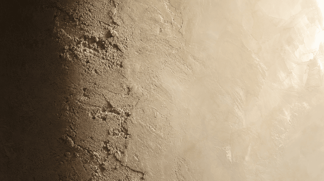 Macro close-up of an interior wall surface in mid-transition: rough sand-plaster texture dissolving from the left edge i