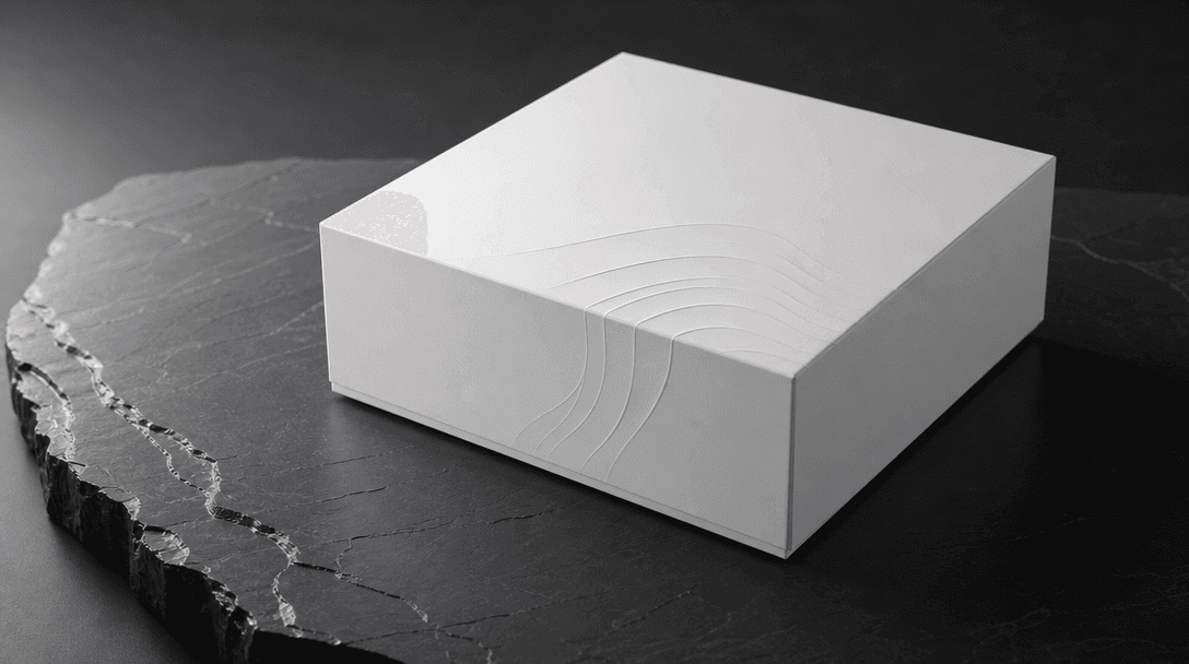 Abstract still representing commercial-grade brand quality: pristine matte white product box with minimal embossed surfa