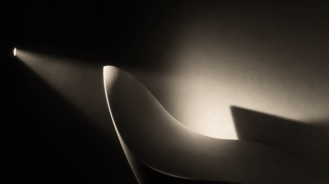 Abstract studio lighting concept: a single intense side-light beam cuts across a dark studio space, illuminating a smoot