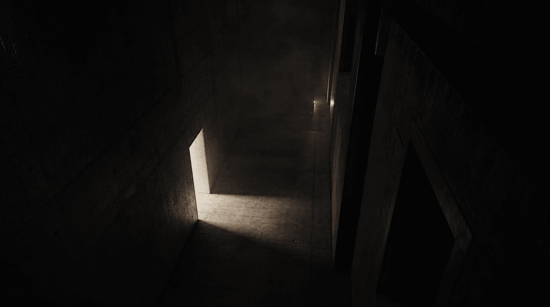 An empty concrete corridor seen from a high fixed angle, one doorway spilling a sharp rectangle of off-white light acros