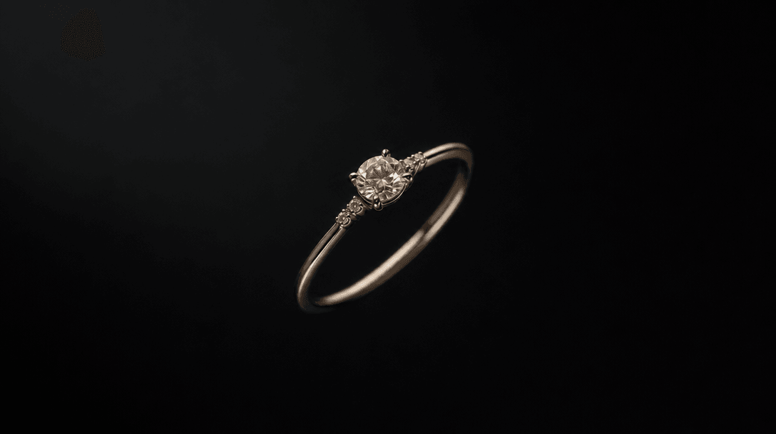 A delicate ring floating in near-void darkness, set against a controlled background gradient transitioning from deep cha