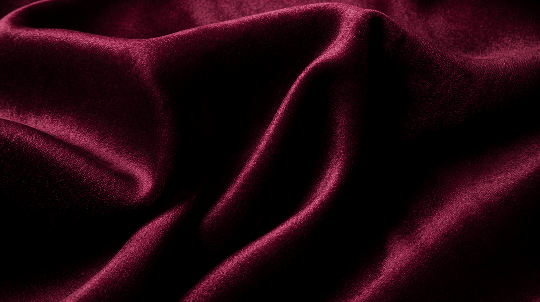 Close-up texture of luxe fabric material, rich deep colors, studio lighting highlight, fashion editorial focus