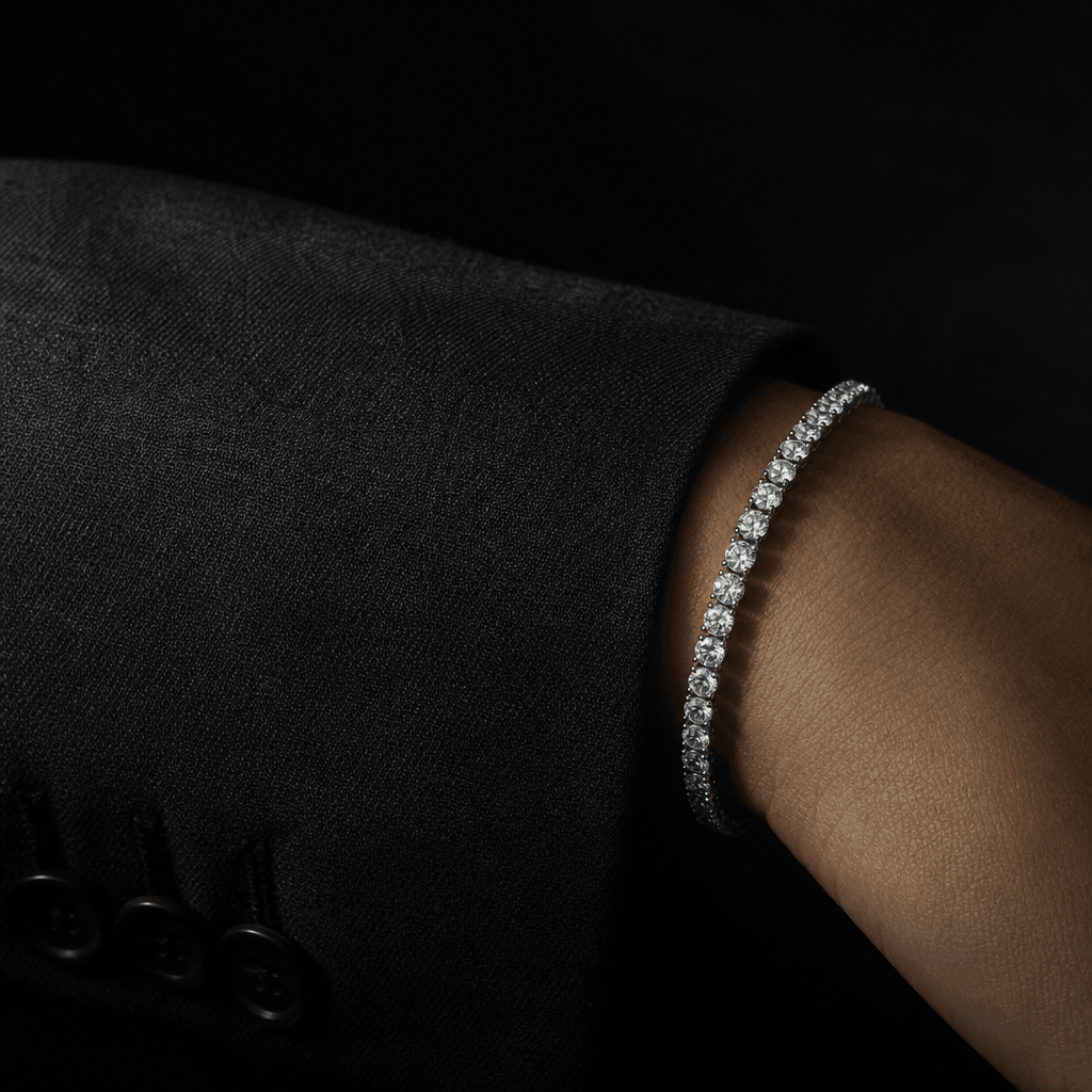 Dark editorial macro of a diamond tennis bracelet resting on the cuff of a tailored charcoal blazer sleeve. Dramatic sin