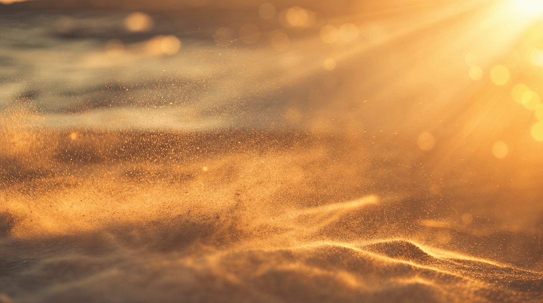 Abstract motion study: fine sand particles lifted by a warm coastal breeze, golden sunlight rays cutting through salt ha