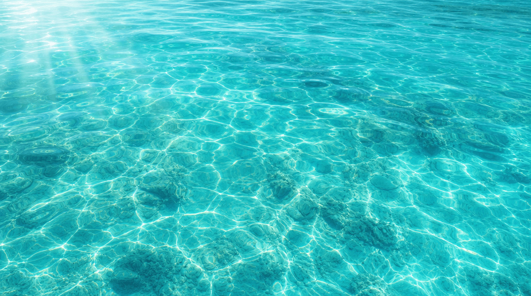 Crystal clear turquoise water with gentle ripples and tropical light rays filtering through. Serene, luxurious lagoon te