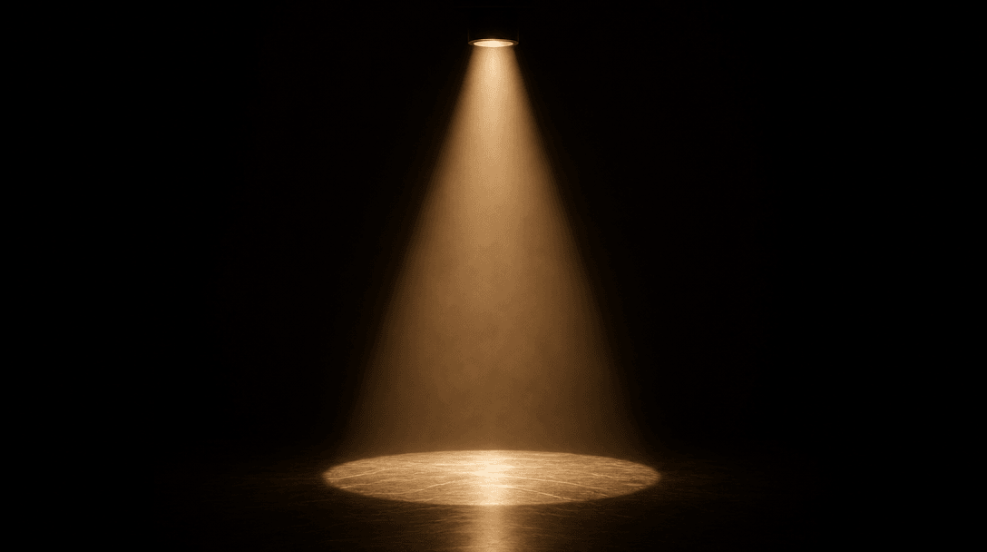 Abstract cinematic still life: a single tight cone of warm studio spotlight cutting through deep darkness and illuminati