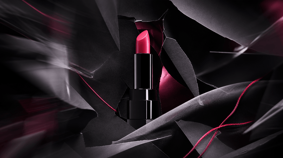 A premium product emerging from layered black paper, fabric, and translucent film arranged like a rapidly assembled camp