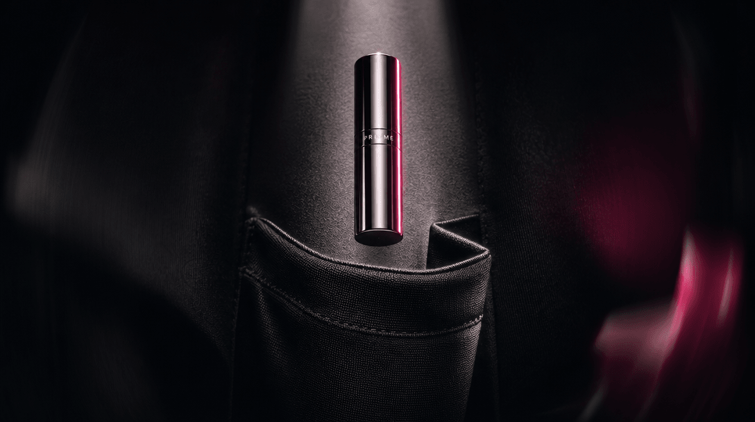 An abstract still life expressing portability: a small polished cosmetic cylinder suspended above folded black fabric sh