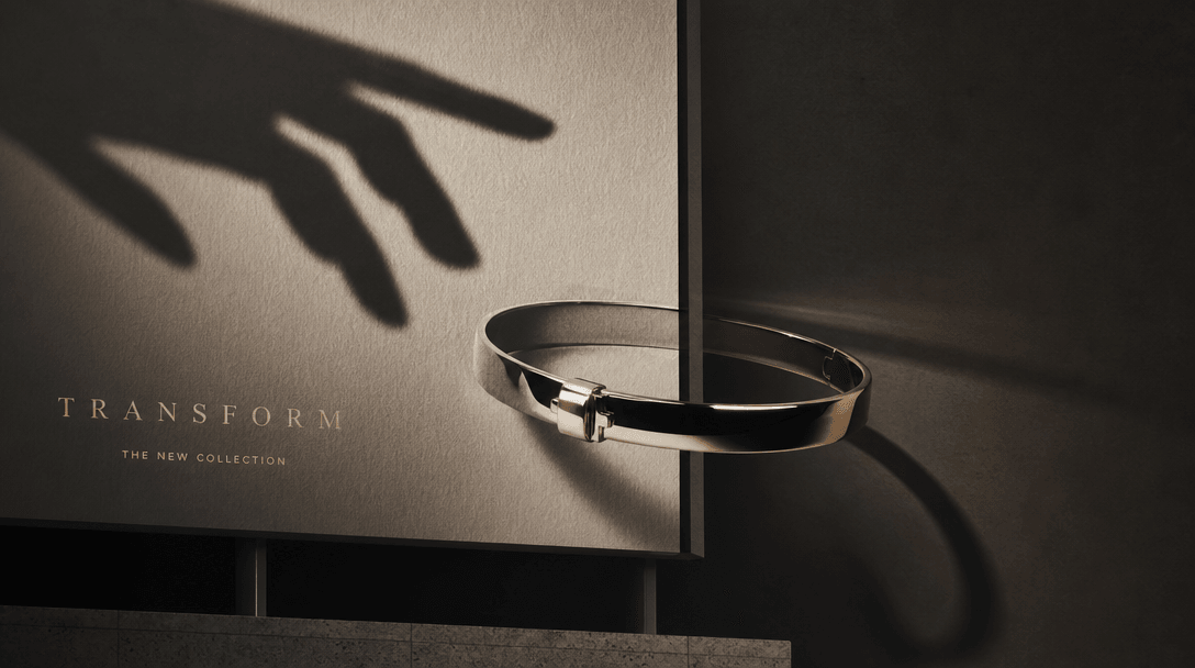 An abstract hand-shaped shadow reaches across a billboard surface as a polished bracelet crosses from printed paper into