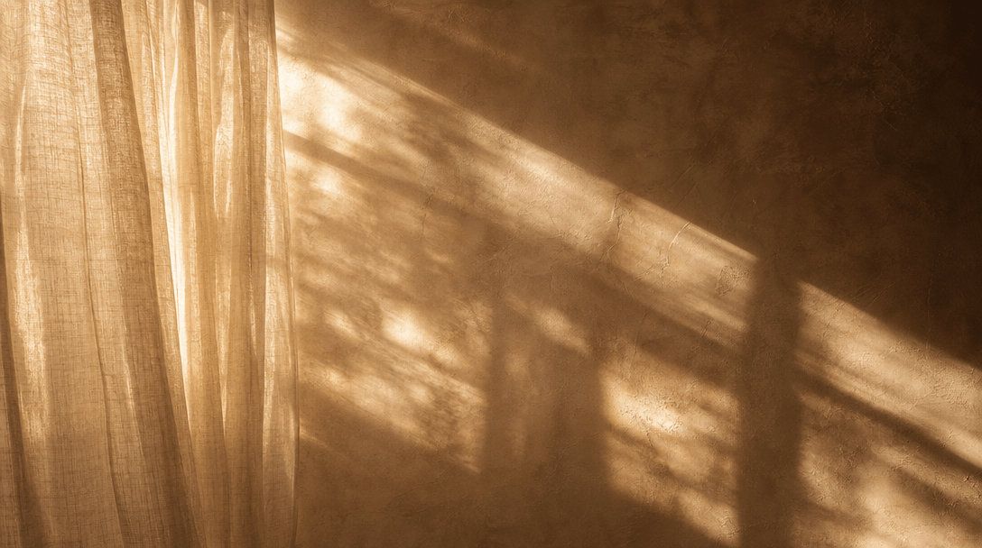 Abstract cinematic frame: sunlight streaming through sheer natural linen curtains in a bare room, casting soft diffused 