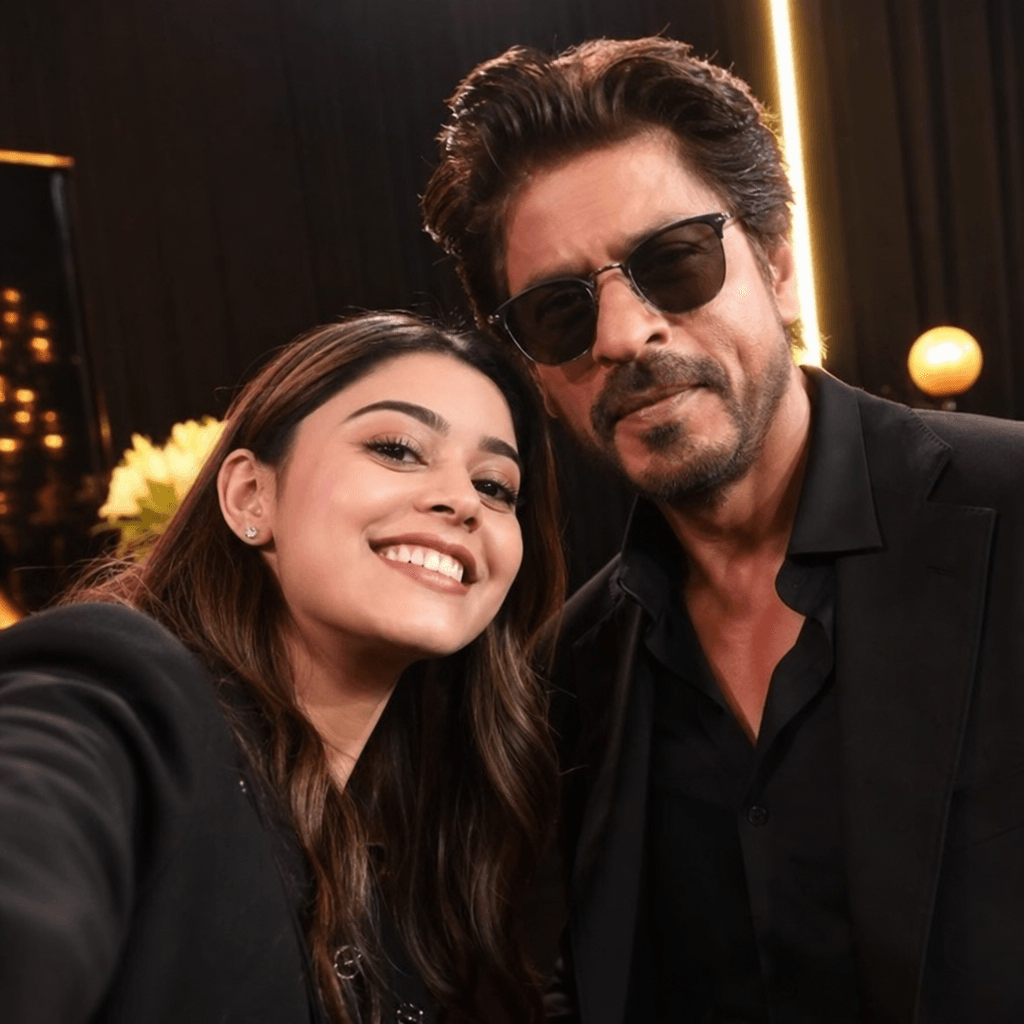 Candid celebrity interaction selfie style, natural studio lighting with warm tones, authentic happy expressions on both 