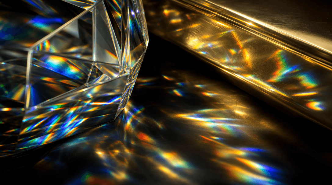 Extreme macro abstraction of light splitting into spectral caustics across a faceted crystal surface beside polished gol