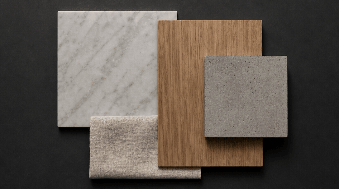 A flat lay of interior material and finish samples — honed marble slab, warm brushed oak veneer, raw concrete tile, natu