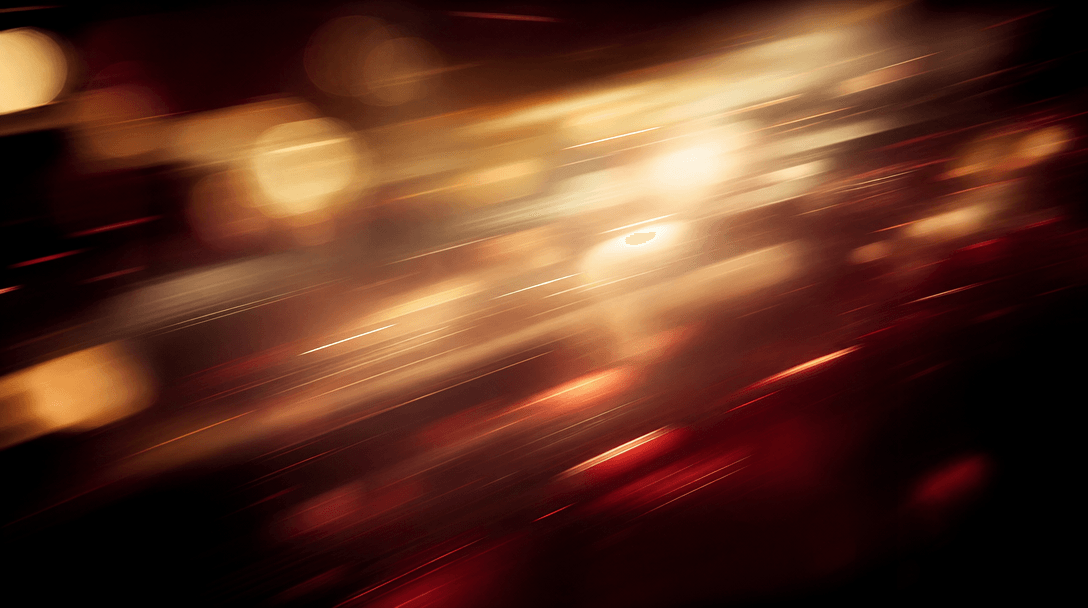 Abstract motion blur of warm amber, cream, and deep burgundy tones — bokeh light streaks suggesting dynamic movement and