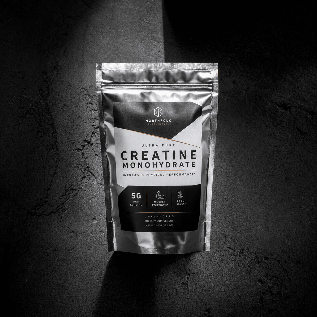 Silver metallic foil supplement pouch standing upright on dark textured concrete, dramatic top-down split light creating