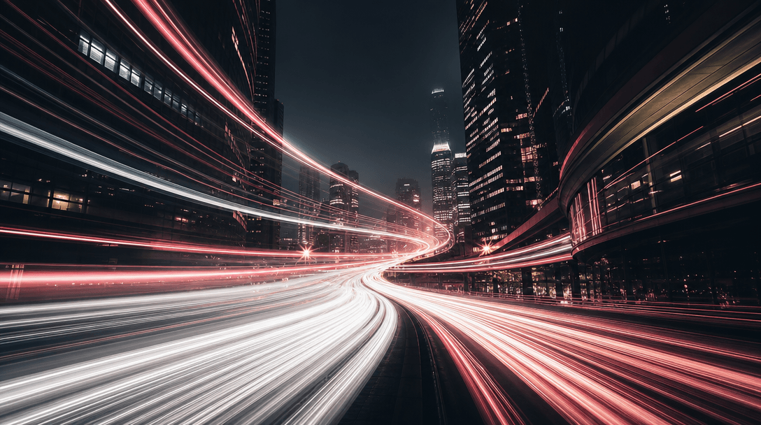 Abstract time-lapse style long-exposure cityscape at night with sweeping light trails of white and warm pink streaking t