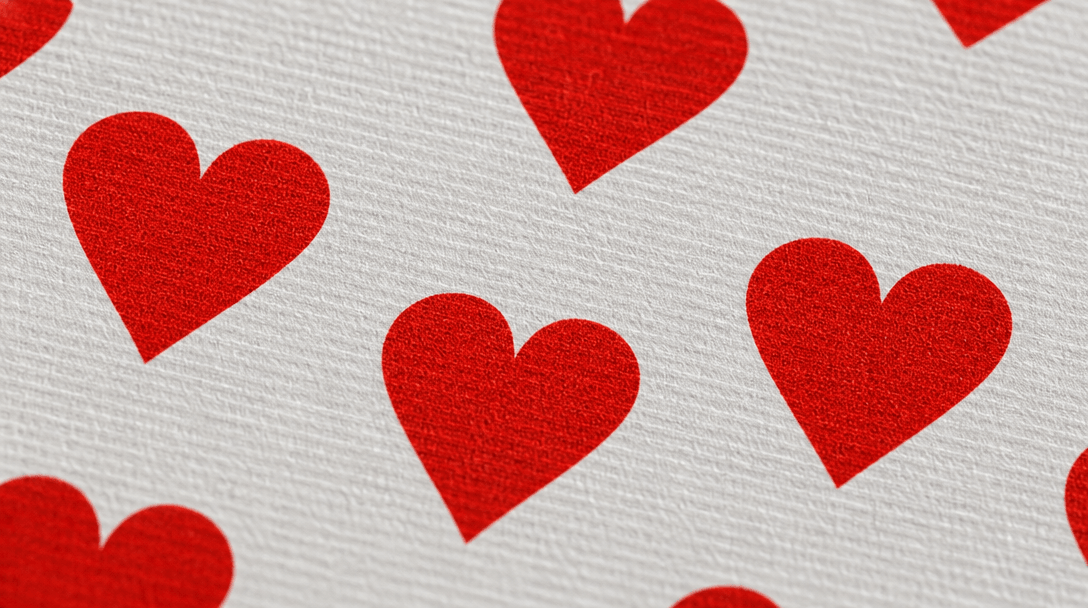 Close-up texture of card stock material, hearts symbol pattern, professional printing quality, studio lighting detail