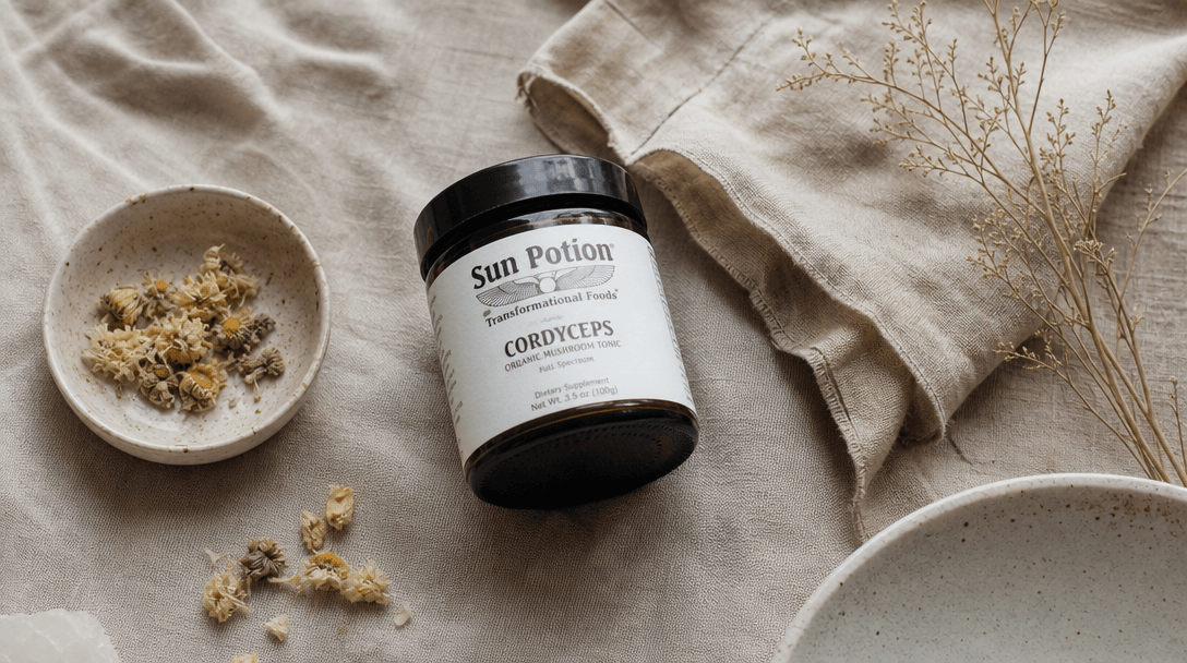 Casual flat-lay of lifestyle objects — a supplement jar, dried botanicals, a linen cloth, a small ceramic dish — arrange