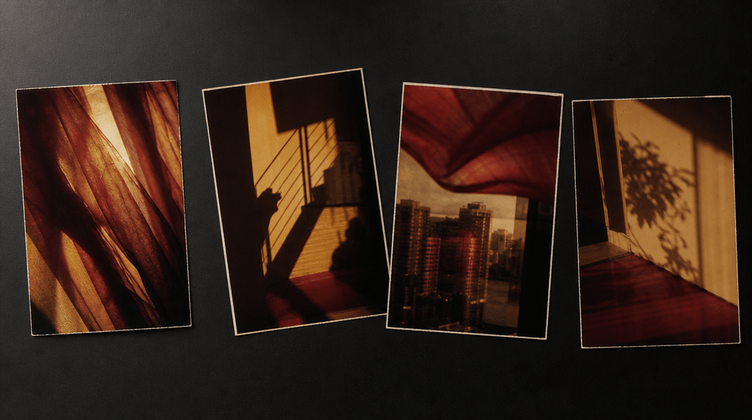 A sequence of four physical color-film photographs arranged loosely on a black studio table, each showing abstract light