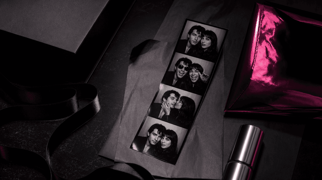 A finished photobooth strip integrated into an elegant campaign still life with folded editorial paper, satin ribbon, me