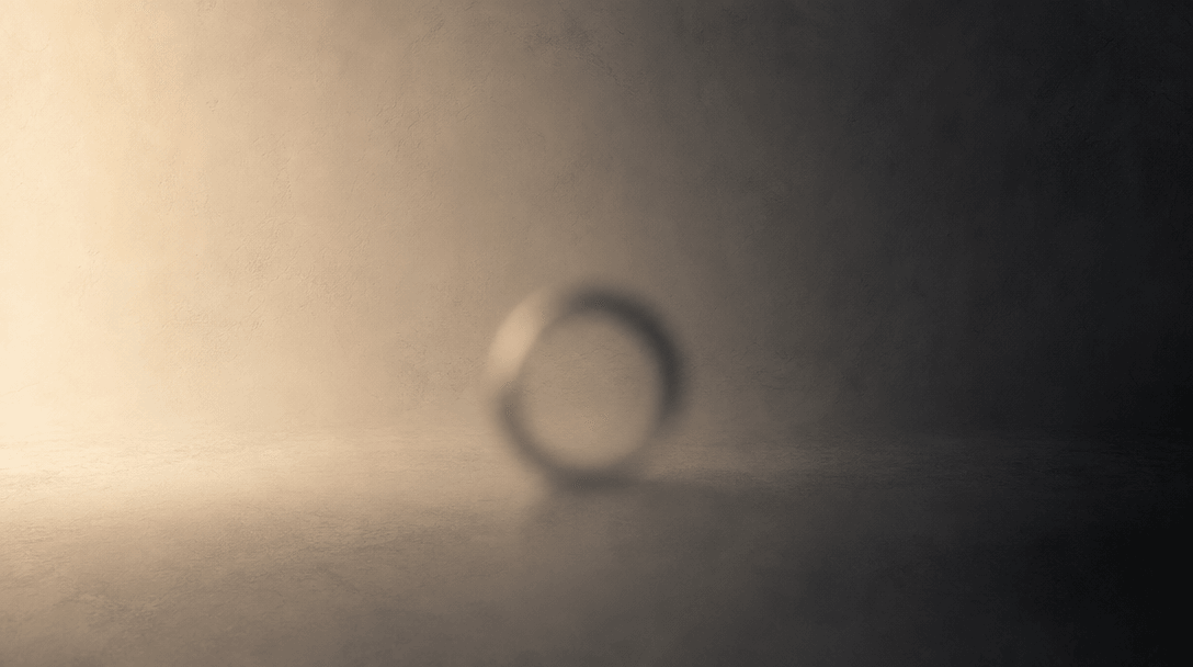Abstract gradient study of a studio background: a smooth transition from warm ivory cream at left to deep charcoal at ri