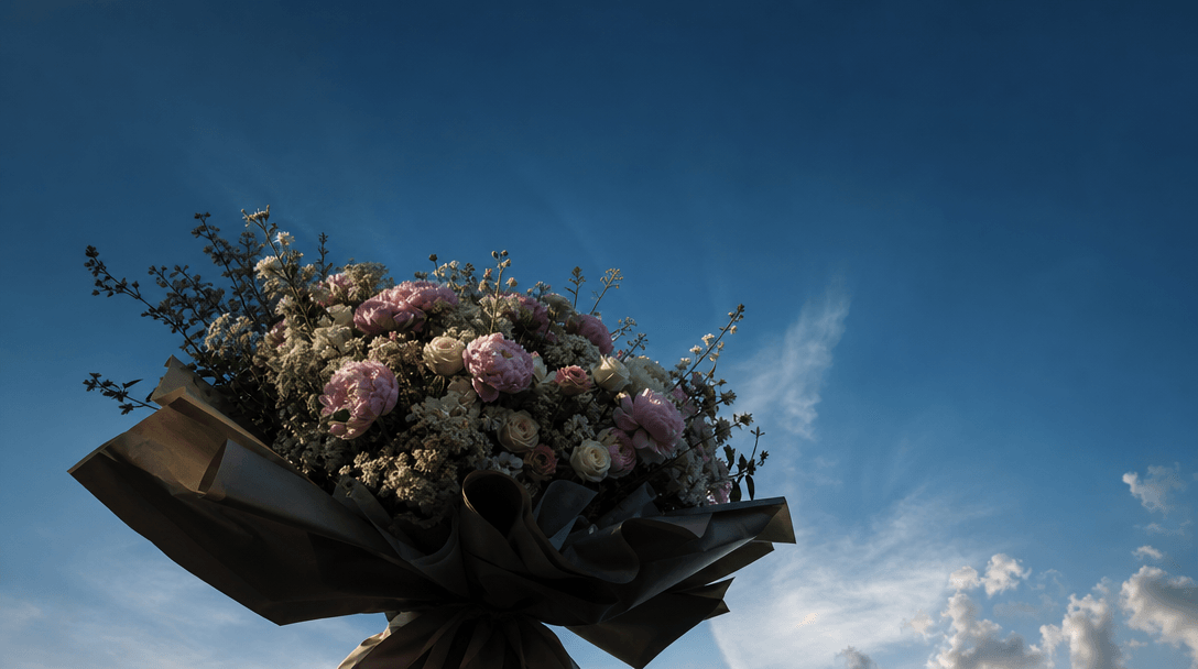 An oversized bouquet silhouette rising into an immense blue sky, viewed from an extreme low angle to communicate scale,