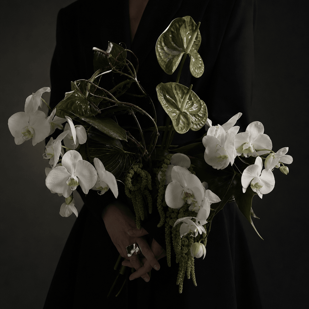Square avant-garde bouquet portrait showing only the torso and hands of a faceless studio model, sculptural white orchid