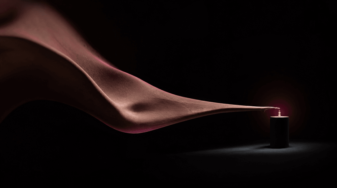 An abstract elongated ribbon of skin-toned sculptural material stretching across a vast black studio toward a small illu