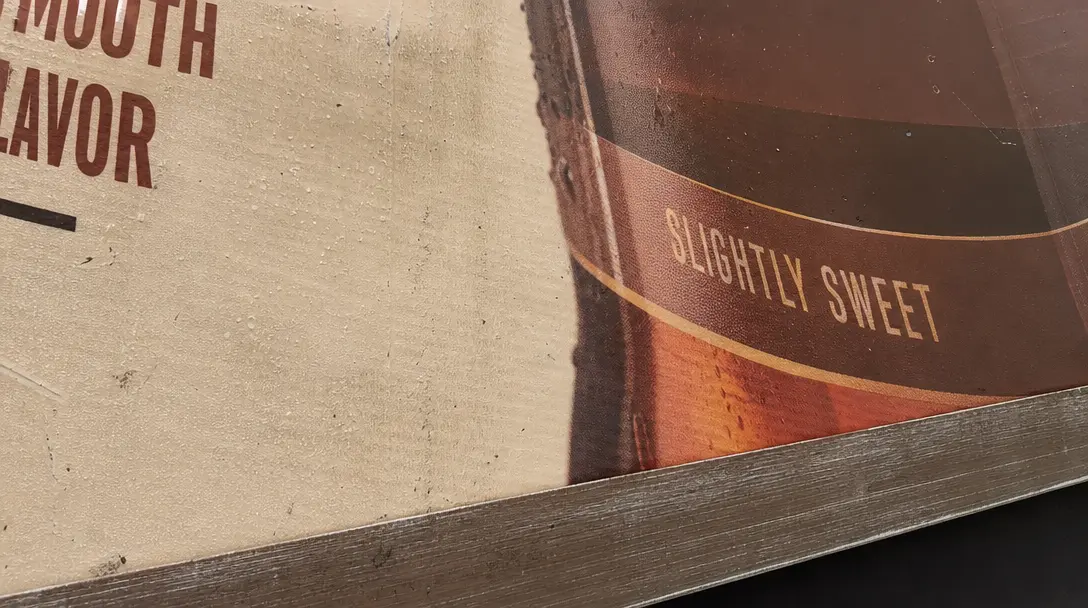Close-up detail of photorealistic billboard surface showing product packaging texture, realistic material reflection and