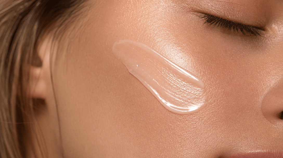 Luxury skincare texture close-up: product application on skin showing glow and luminosity. Macro photography, soft golde