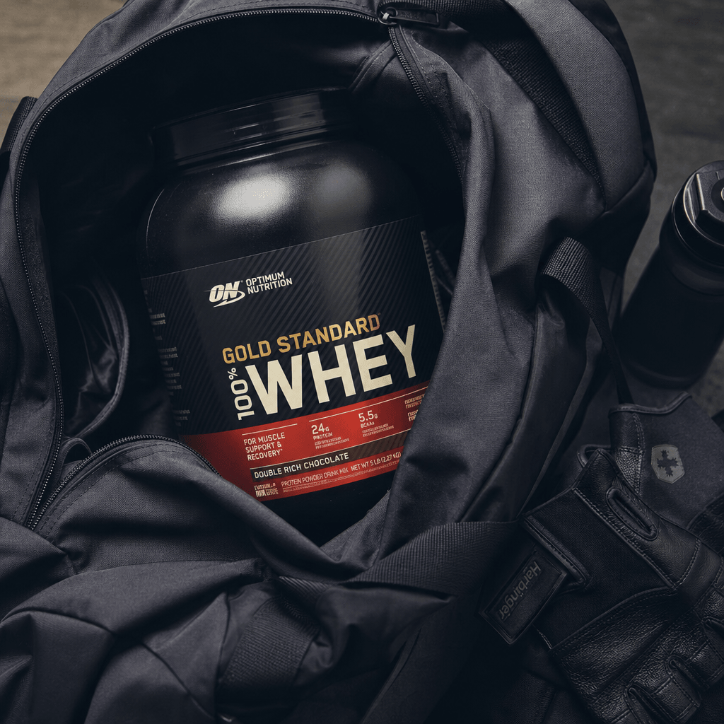 Protein supplement tub nestled in an open gym bag with workout gloves resting nearby, overhead flat-lay angle, cool athl