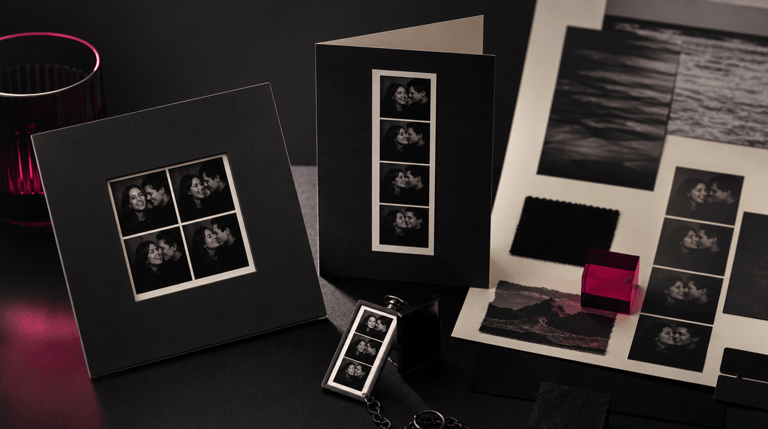 A completed photo strip transforming into multiple elegant physical formats across a dark studio table: a square print,