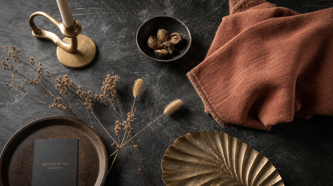Editorial lifestyle flat lay overhead shot of home decor accessories arranged artfully on a dark slate surface: small sc