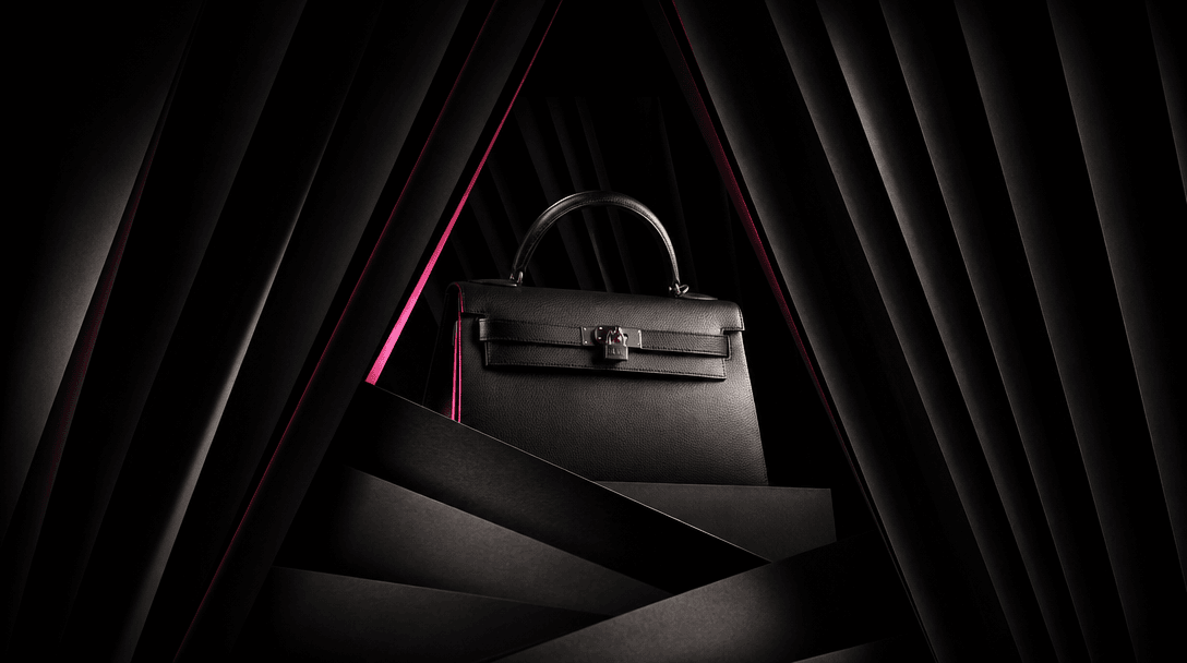 A luxury product emerging from layered black curtains and sculptural paper planes, symbolizing curated creative directio