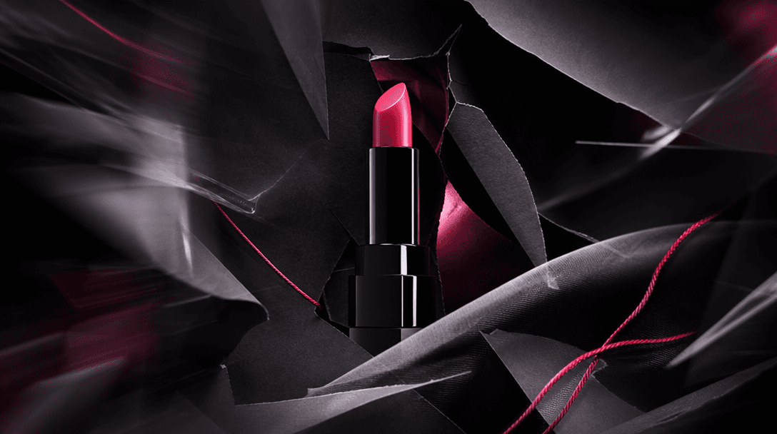 A premium product emerging from layered black paper, fabric, and translucent film arranged like a rapidly assembled camp