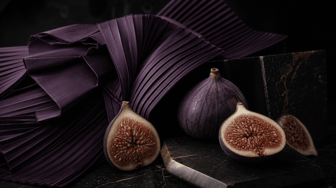 A sculptural still life contrasting rigid pleated violet fabric with soft figs cut open to reveal intricate interiors, n