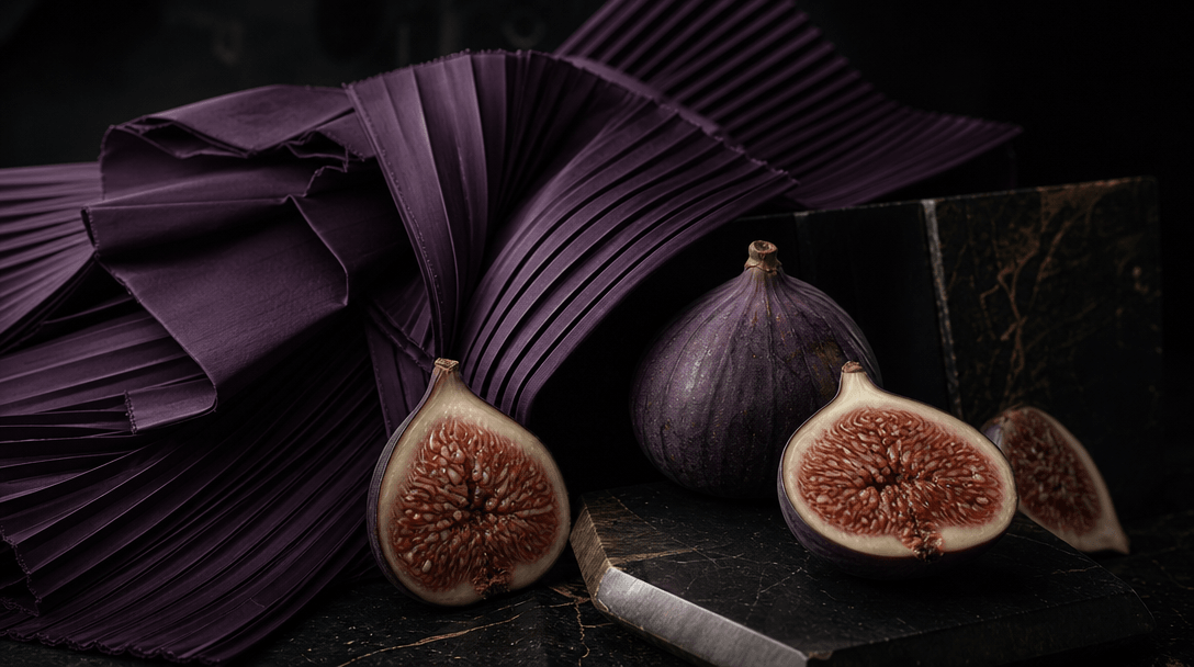 A sculptural still life contrasting rigid pleated violet fabric with soft figs cut open to reveal intricate interiors, n