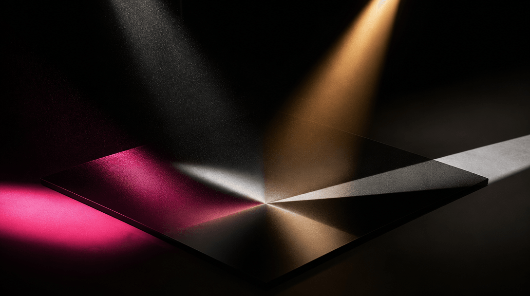 Four distinct beams of studio light converge onto a single polished black photographic surface, each beam carrying a dif