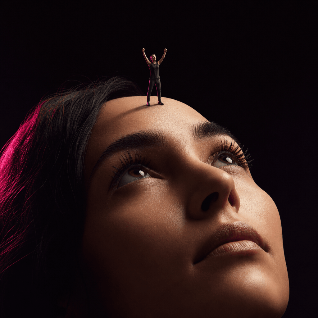 Tiny figure in triumphant pose with raised arms standing on forehead, dramatic side-lit cinema lighting, deep black back