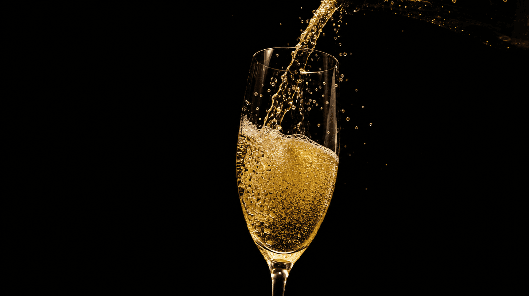 Champagne pour in slow-motion — gold liquid cascading into a crystal flute, bubbles rising, against a pure dark backgrou