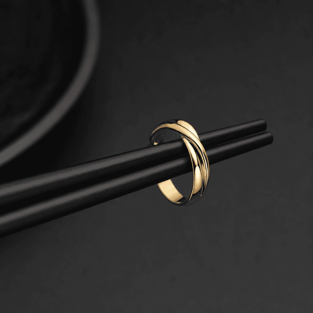 Gold ring resting elegantly on minimalist chopsticks, dark background, soft professional lighting, luxury jewelry minima