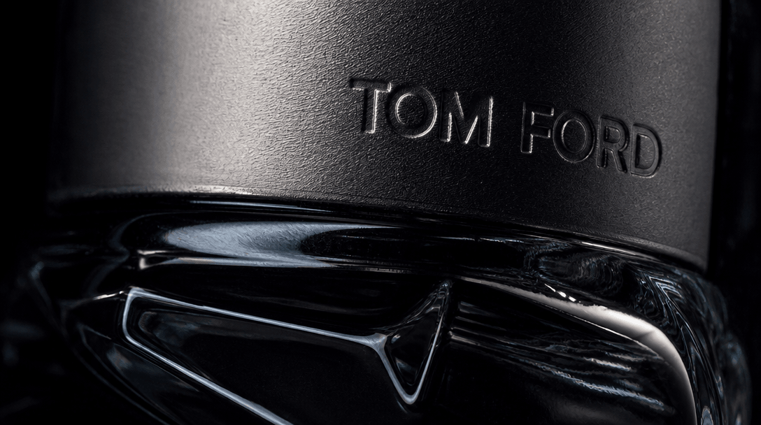 Extreme close-up studio texture: the surface of a luxury product — polished obsidian glass, brushed matte metal cap, emb